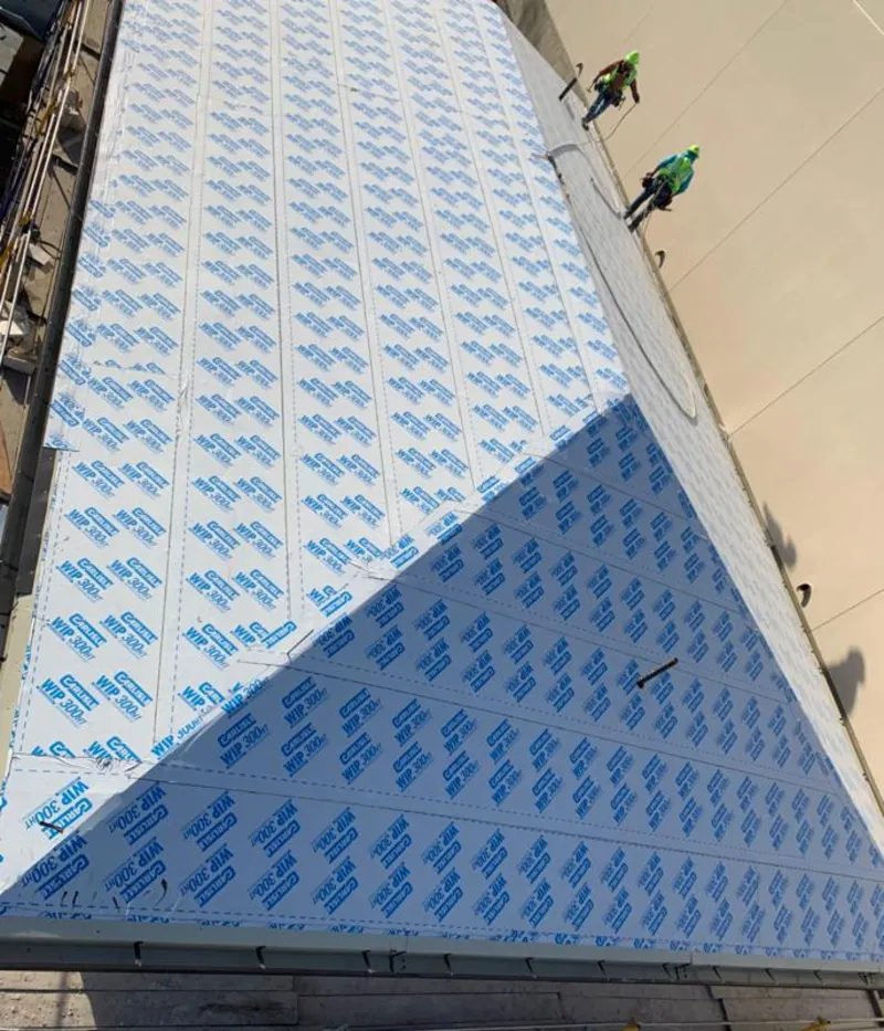 Professional roofers installing underlayment on a metal roof in Olivarez